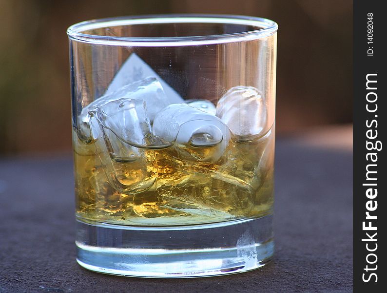 Whiskey in a glass tumbler with ice cubes