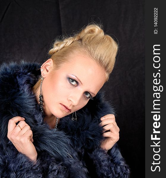 Girl in a fur coat on a black background