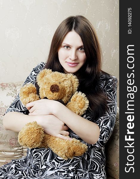 The image of a beautiful pregnant woman sitting on a vintage couch