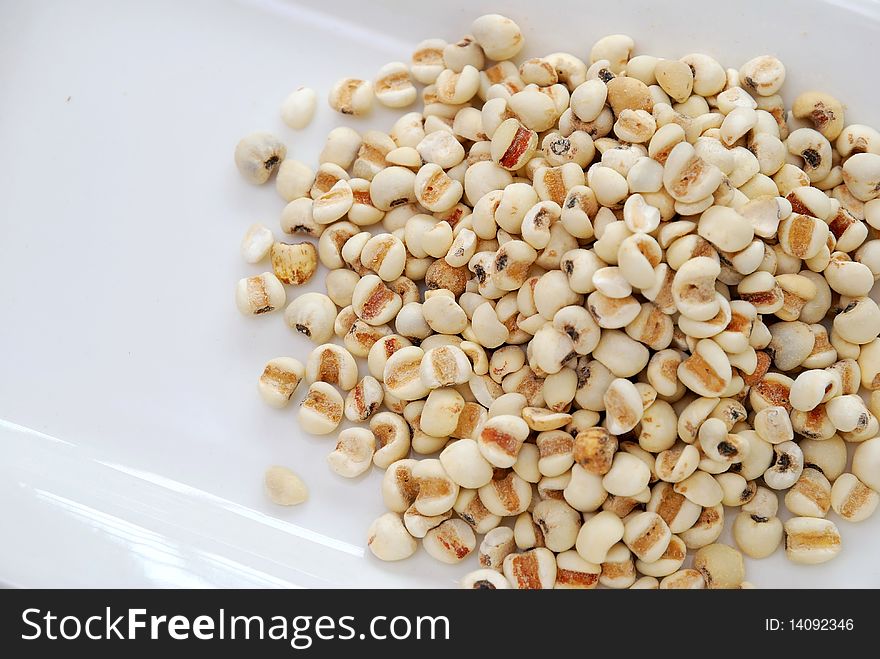 Dried barley seeds on white plate. Commonly used as a food ingredient in many Chinese cuisine and desserts. For food and beverage, and diet and nutrition concepts.