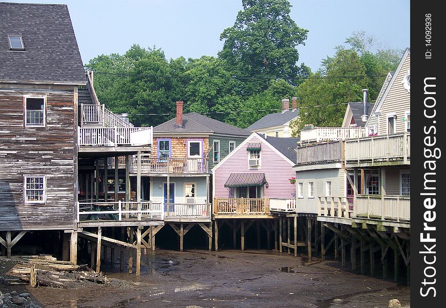 A beautiful landscape in Maine shows the piers and buildings set up high while the tide is out and the markings from water level when it comes in again. . A beautiful landscape in Maine shows the piers and buildings set up high while the tide is out and the markings from water level when it comes in again. .