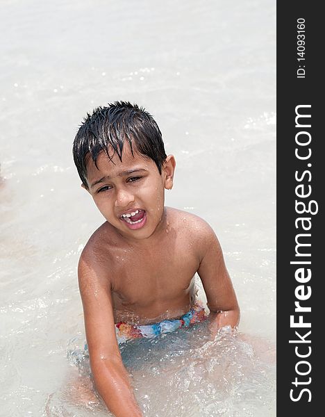 An handsome Indian kid playing in the water