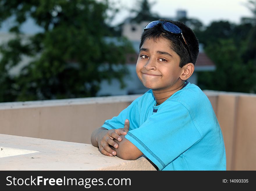 A handsome Indian kid model posing with his sun glasses. A handsome Indian kid model posing with his sun glasses