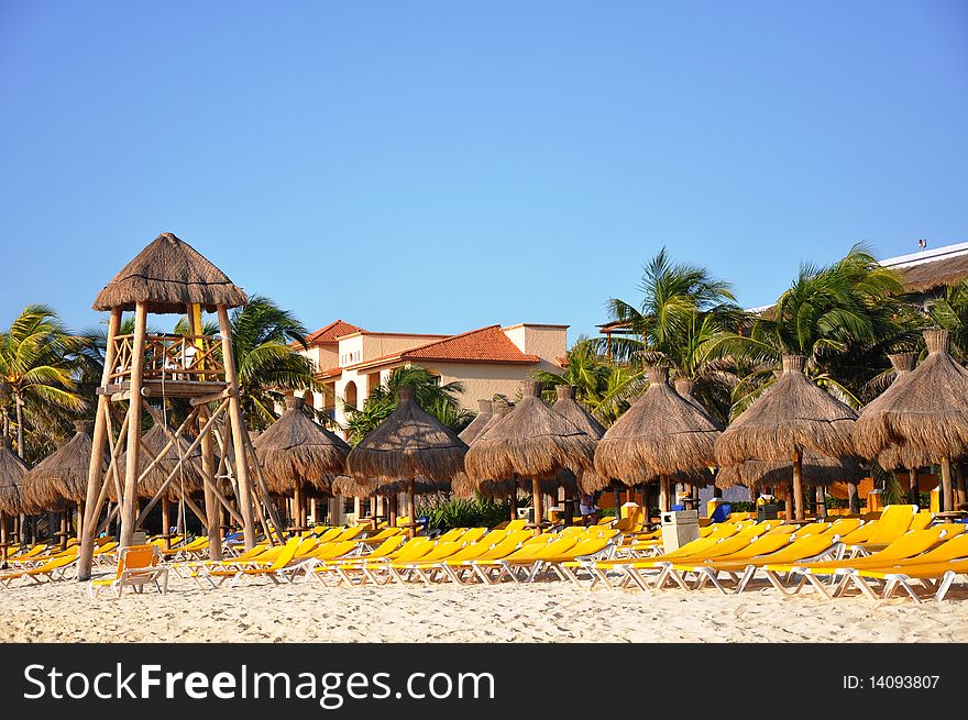 Sand, empty yellow plank beds, grassy umbrellas and the sea. Sand, empty yellow plank beds, grassy umbrellas and the sea.