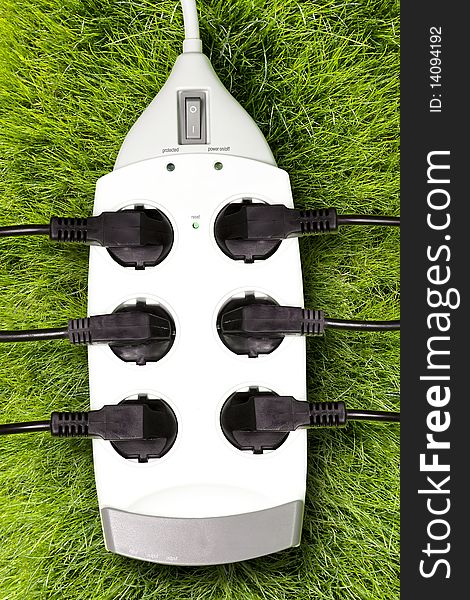 White outlet over grass; green energy concept. White outlet over grass; green energy concept