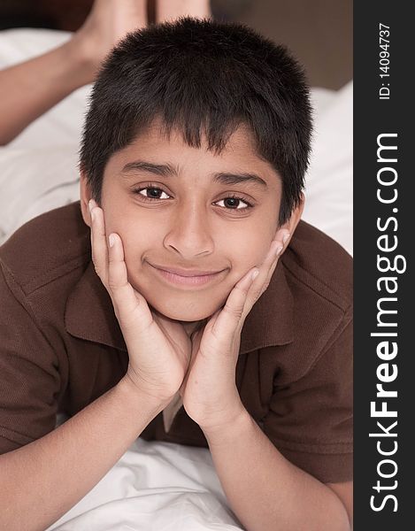 Handsome Indian kid lying happily on the bed. Handsome Indian kid lying happily on the bed