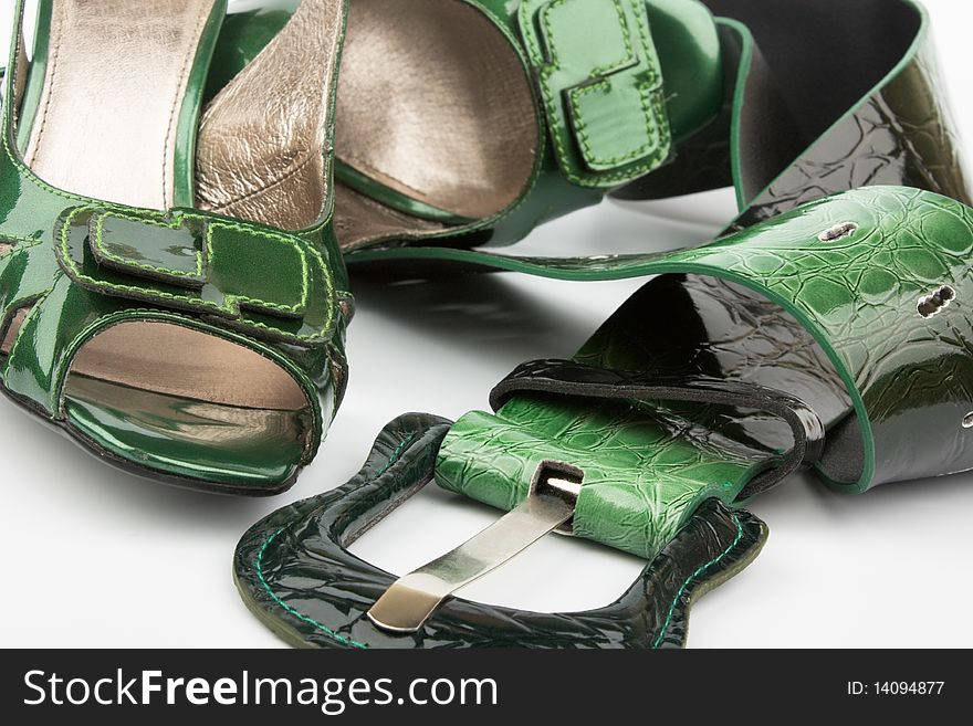 Green high heels shoes and belt on white
