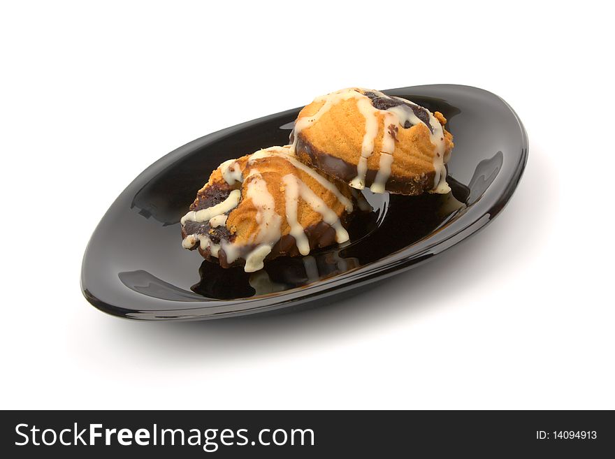 Cookies in chocolate on black plate isolated on white