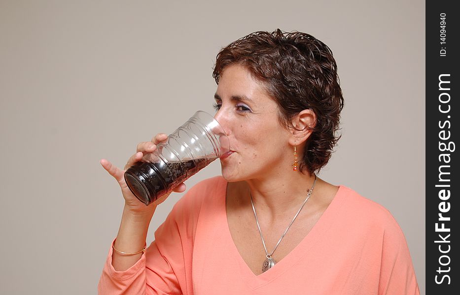 Young woman drinking a glass of soda. Young woman drinking a glass of soda