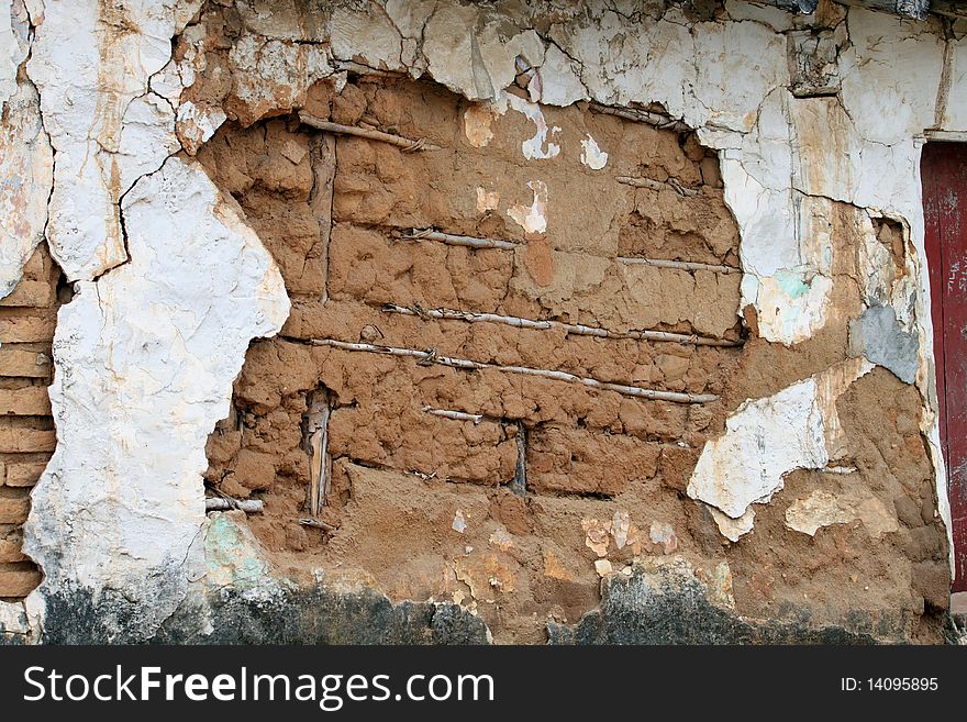 Adobe mud wall with plaster cracking. Adobe mud wall with plaster cracking