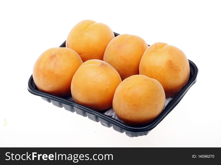 Some ripe apricot with the dark plastic box.(isolated on white background.). Some ripe apricot with the dark plastic box.(isolated on white background.)