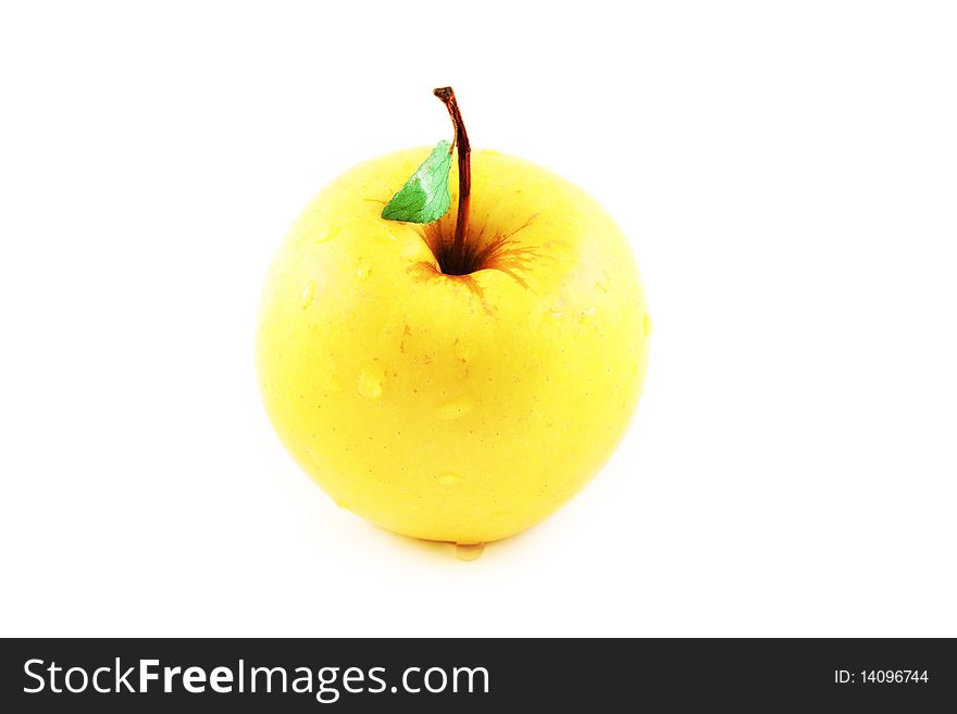 Yellow golden apple with a green leaf, with water drops, isolated on white