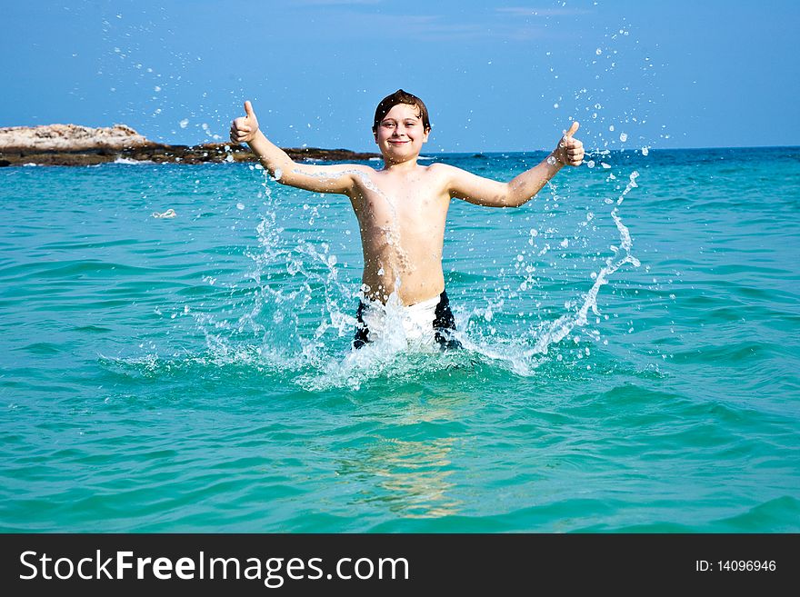 Smiling boy enjoys swimming  in the sea