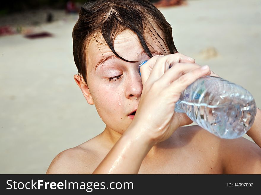 Young happy boy with brown wet hair looks into a bottle. Young happy boy with brown wet hair looks into a bottle