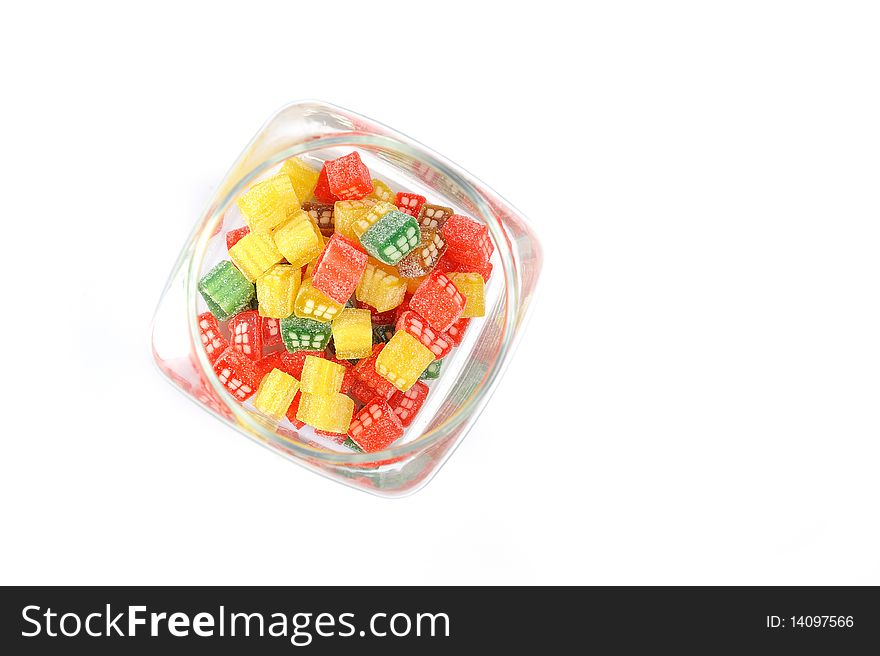 Delicious sweet candies in sugar in a glass jar. white background. copy-space