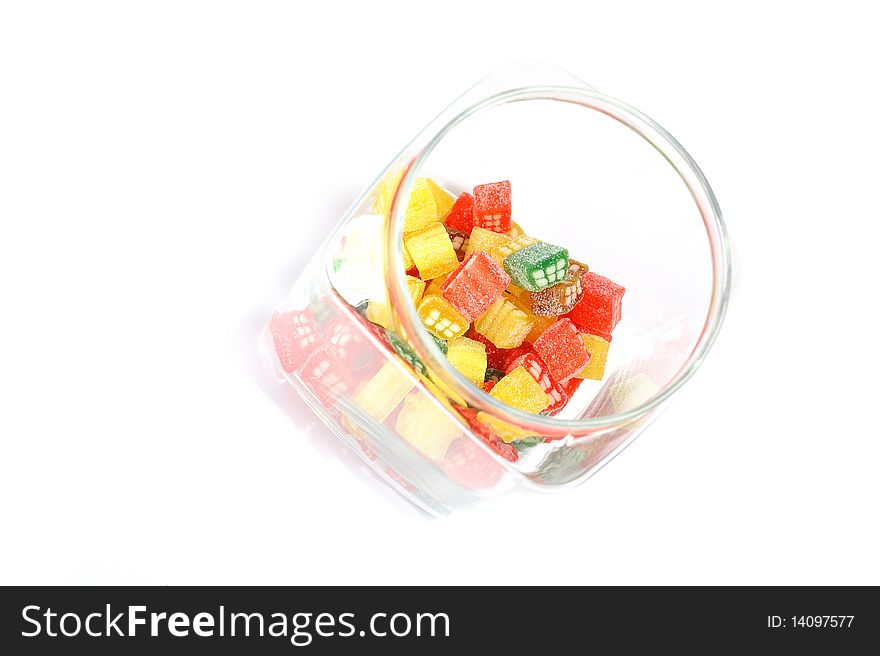 Delicious sweet candies in sugar in a glass jar. white background. copy-space