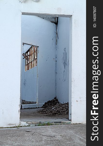 Two doorways and the remains of a metal window of an abandoned building. Two doorways and the remains of a metal window of an abandoned building