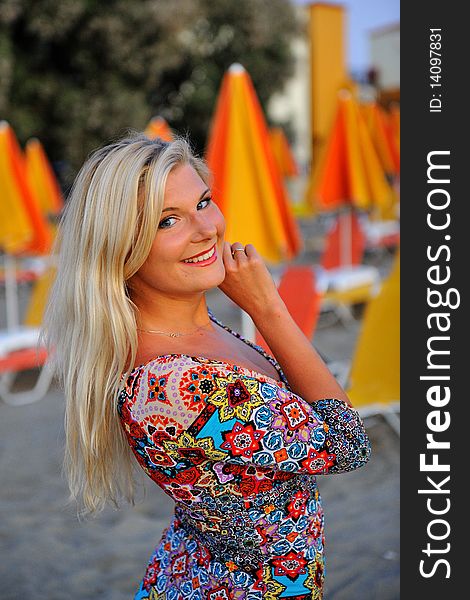 Young pretty woman enjoing the evening on the beach holding her shoes. Young pretty woman enjoing the evening on the beach holding her shoes