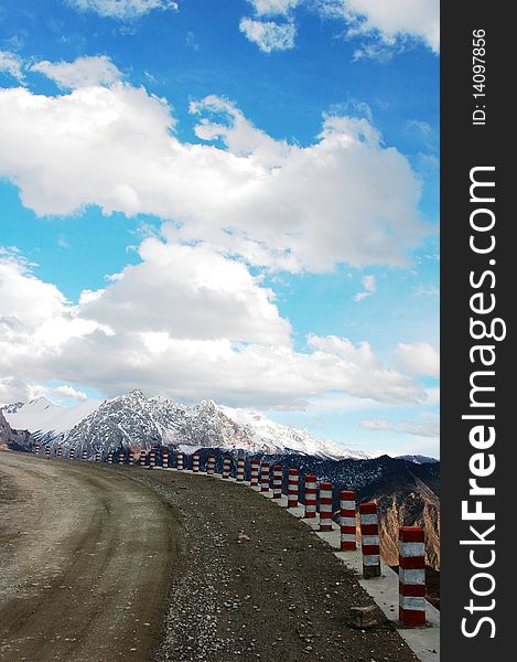 Scenery of a road in the highlands of Tibet with snow mountains and white clouds as backgrounds. Scenery of a road in the highlands of Tibet with snow mountains and white clouds as backgrounds