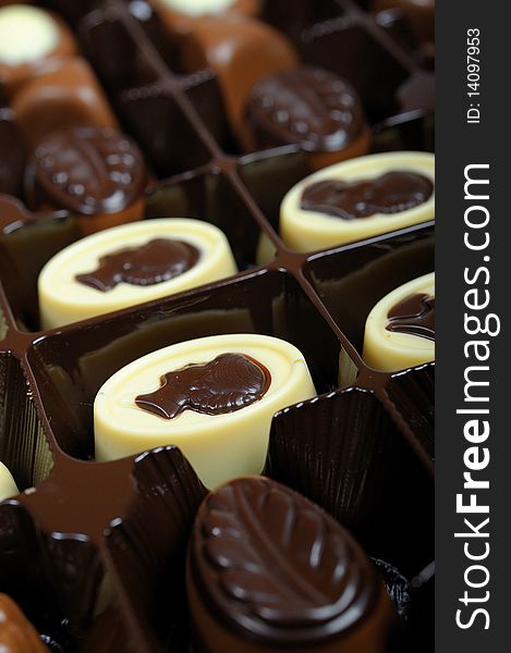 Delicious background of swiss dark chocolates, milk chocolates, pralines and truffles