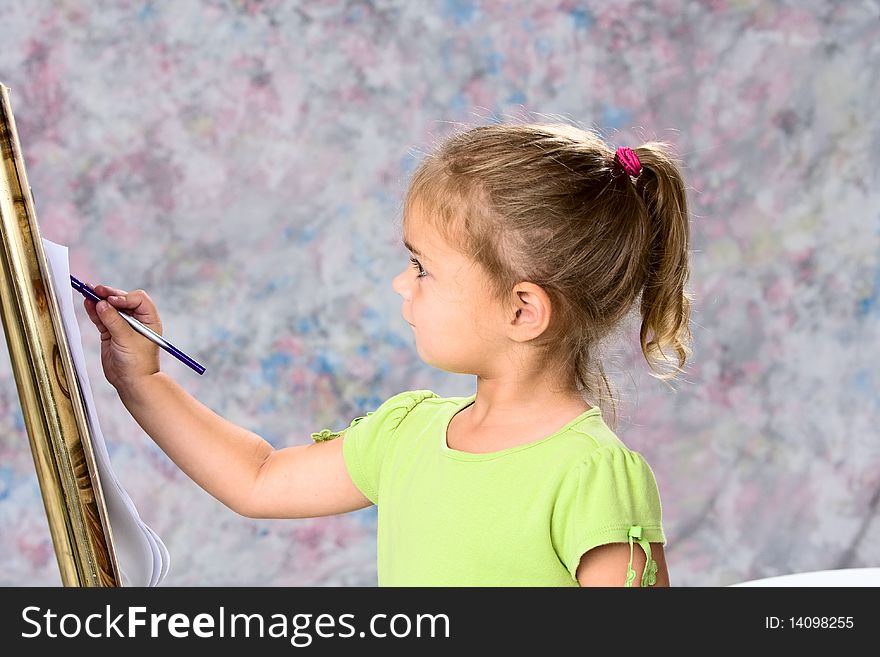 Cute little girl in green blouse painting with water colors. Painted background. Cute little girl in green blouse painting with water colors. Painted background.