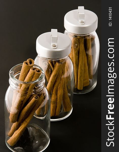 Cinnamon sticks in glass pots, studio shot, close up