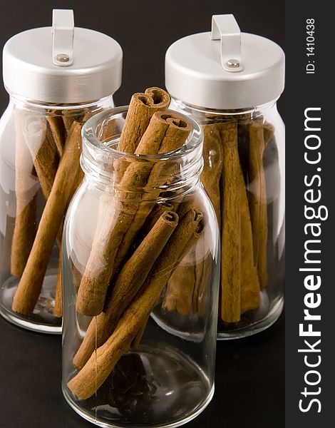 Cinnamon sticks in glass pots, studio shot, close up