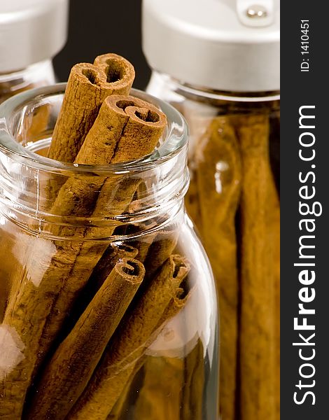 Cinnamon sticks in glass pots, studio shot, close up