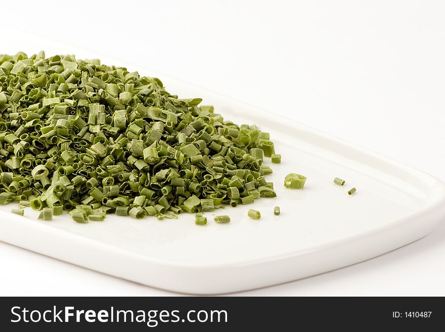 Freeze dried chives on a plate against a white background, Studio shot.