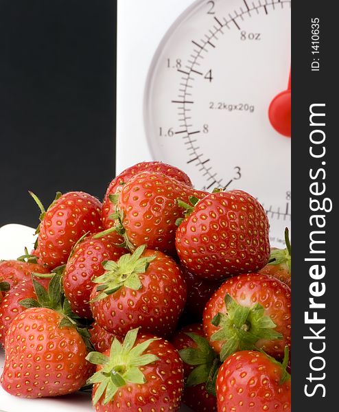 Ripe Strawberry's with Weight Scales shot against a plain background.