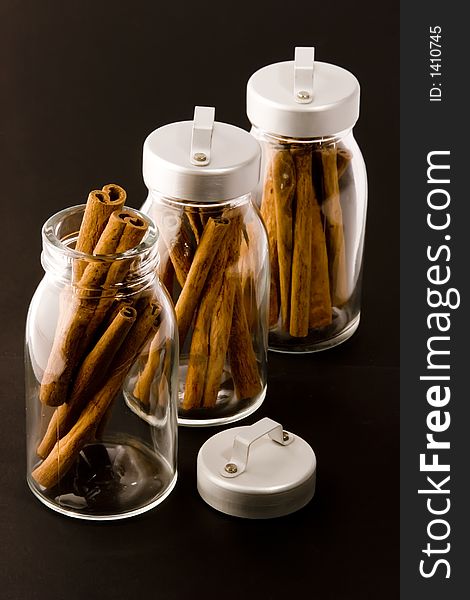 Cinnamon sticks in glass pots, studio shot, close up