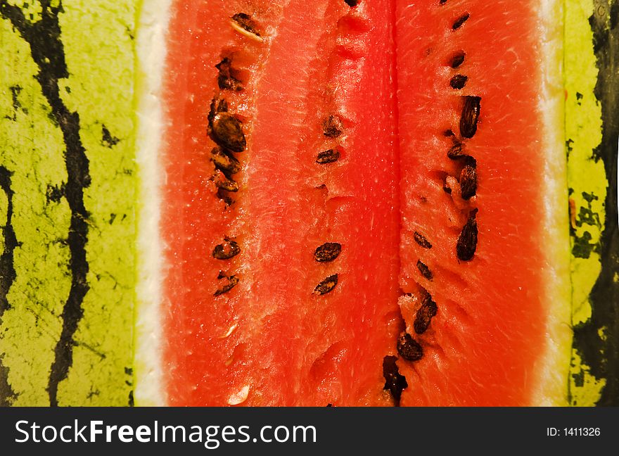 A bright red-green water-melon close-up. A bright red-green water-melon close-up