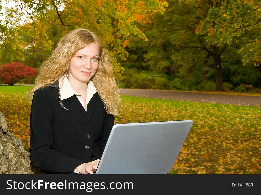 Woman with Laptop in Park.