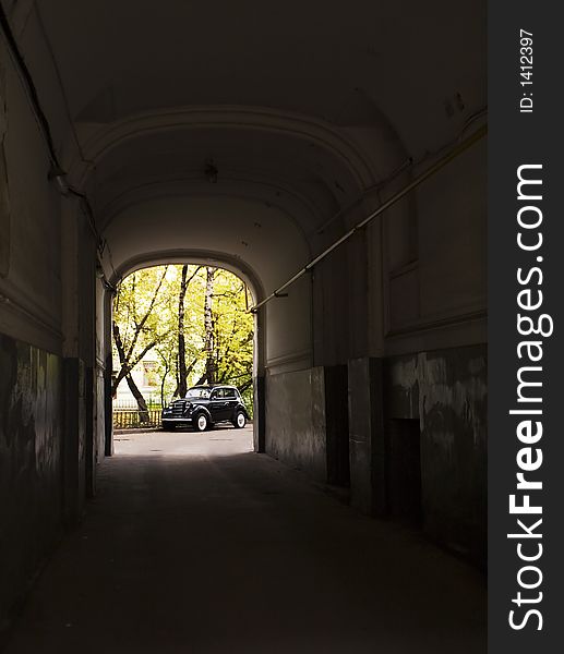 The old automobile stopped opposite to an arch