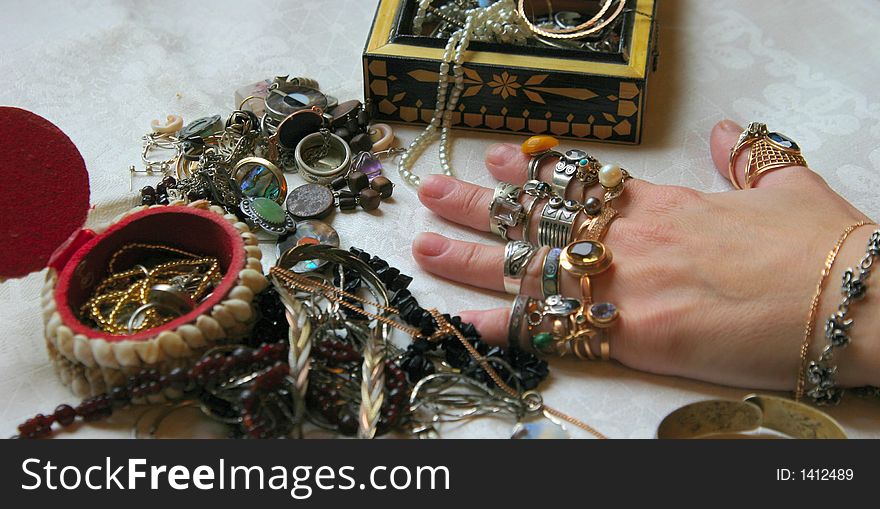 Jeweller ornaments on a table and on a hand. Jeweller ornaments on a table and on a hand