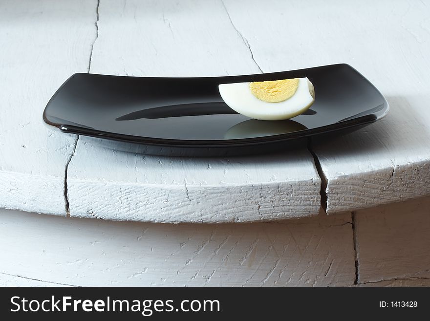 Sliced egg on a black plate. Sliced egg on a black plate