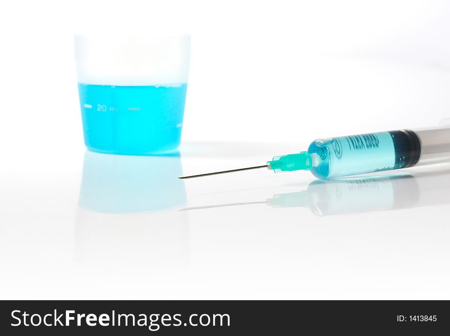 Syringe and medicin blue liquid with reflection