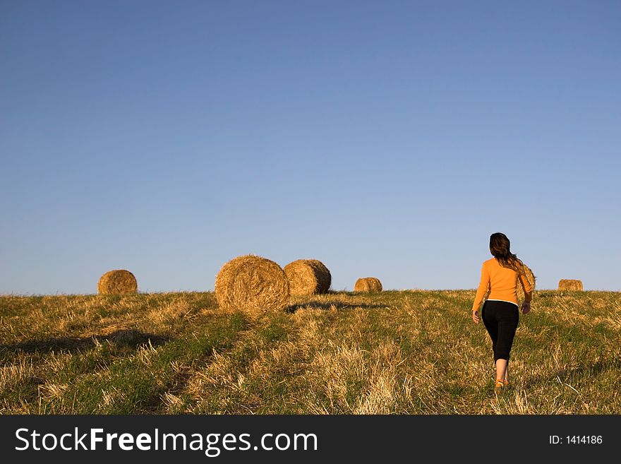Woman running on a hay balles field