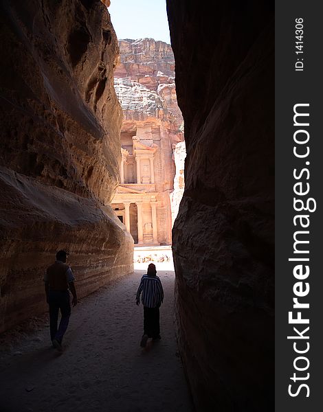 The ancient deserted city of Petra, Jordan, with the Treasury coming into view between the edges of the gorge. The ancient deserted city of Petra, Jordan, with the Treasury coming into view between the edges of the gorge