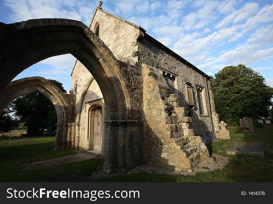 A beautiful ruined but still consecrated church in England under late afternoon sunlight and a blue sky with some clouds. A beautiful ruined but still consecrated church in England under late afternoon sunlight and a blue sky with some clouds