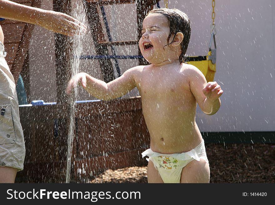 Young Child Getting Wet in Sprinkler. Young Child Getting Wet in Sprinkler