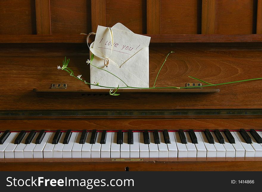 On the piano the envelope with a recognition in love and ring lays