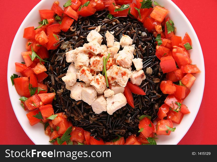 Black rice with boiled chicken breast and tomatoes on a white plate. Black rice with boiled chicken breast and tomatoes on a white plate.
