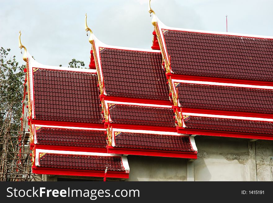Asian architecture evident in red roof design on a Buddhist temple in southern Thailand.