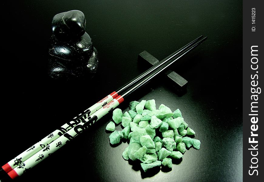 Hot black stones and chopstick whit green stones. Hot black stones and chopstick whit green stones