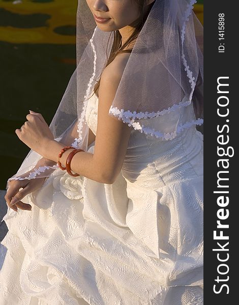 An asian wedding bride posing in the park.