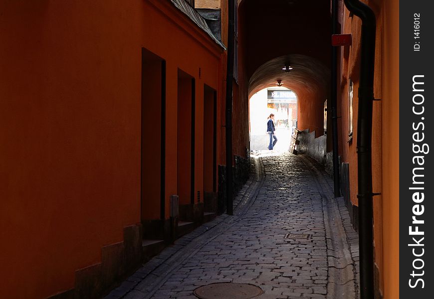 An Alley in Gamla Stan, the old Medieval part of Stockholm, Sweden, on a beautiful day, with a young girl in the background. An Alley in Gamla Stan, the old Medieval part of Stockholm, Sweden, on a beautiful day, with a young girl in the background.