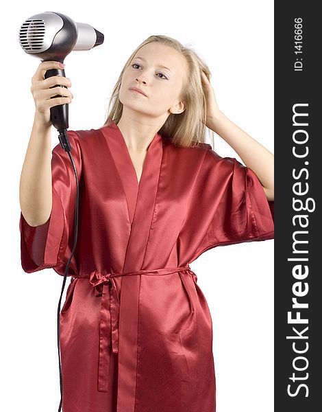 Young woman dressed red bathrobe using  hair drier