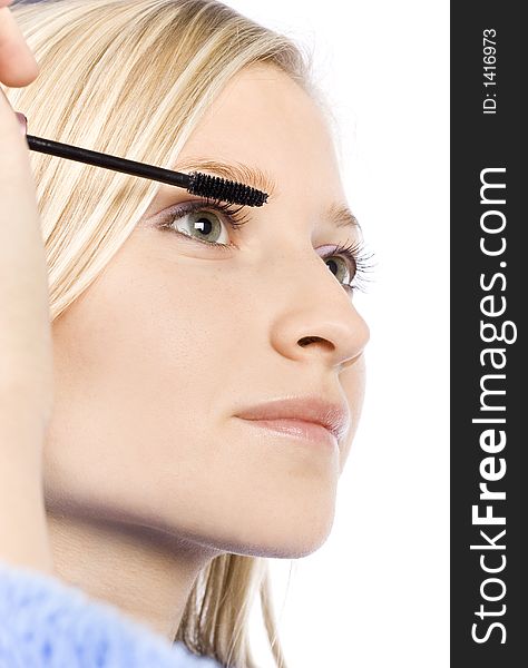 Closeup of young woman's face putting mascara (pure white background)