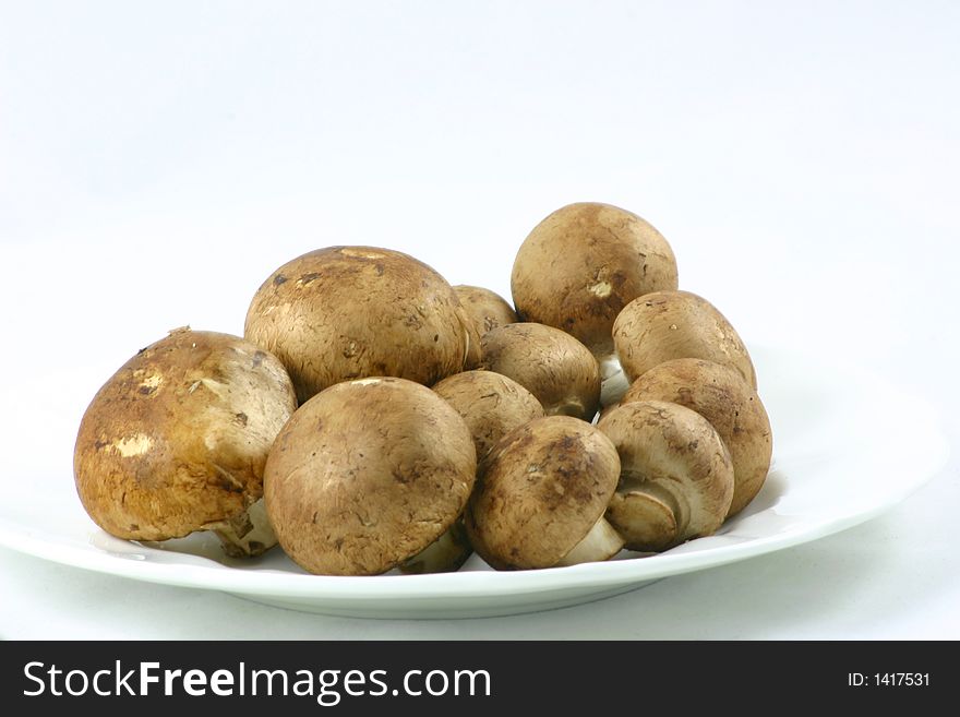 Raw whole chestnut mushrooms on a plate